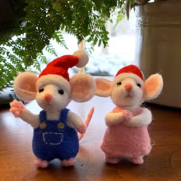 Two festive needle-felted mice beneath greenery