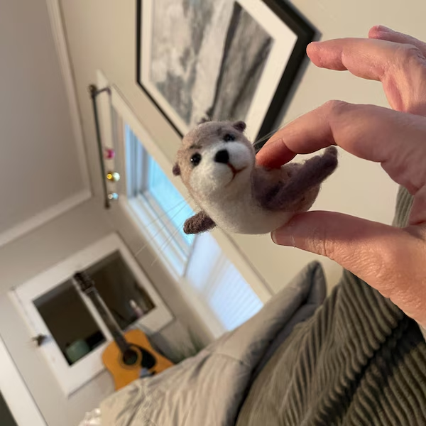 A needle-felted seal held in a customer's hand